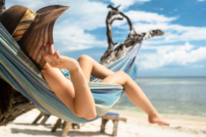 Frau am Strand entspannt in Hängengematte am Meer sonnenschutz-sonnenbrand-kosmetik-studio-stuttgart-carola-kiesel-beauty-balance